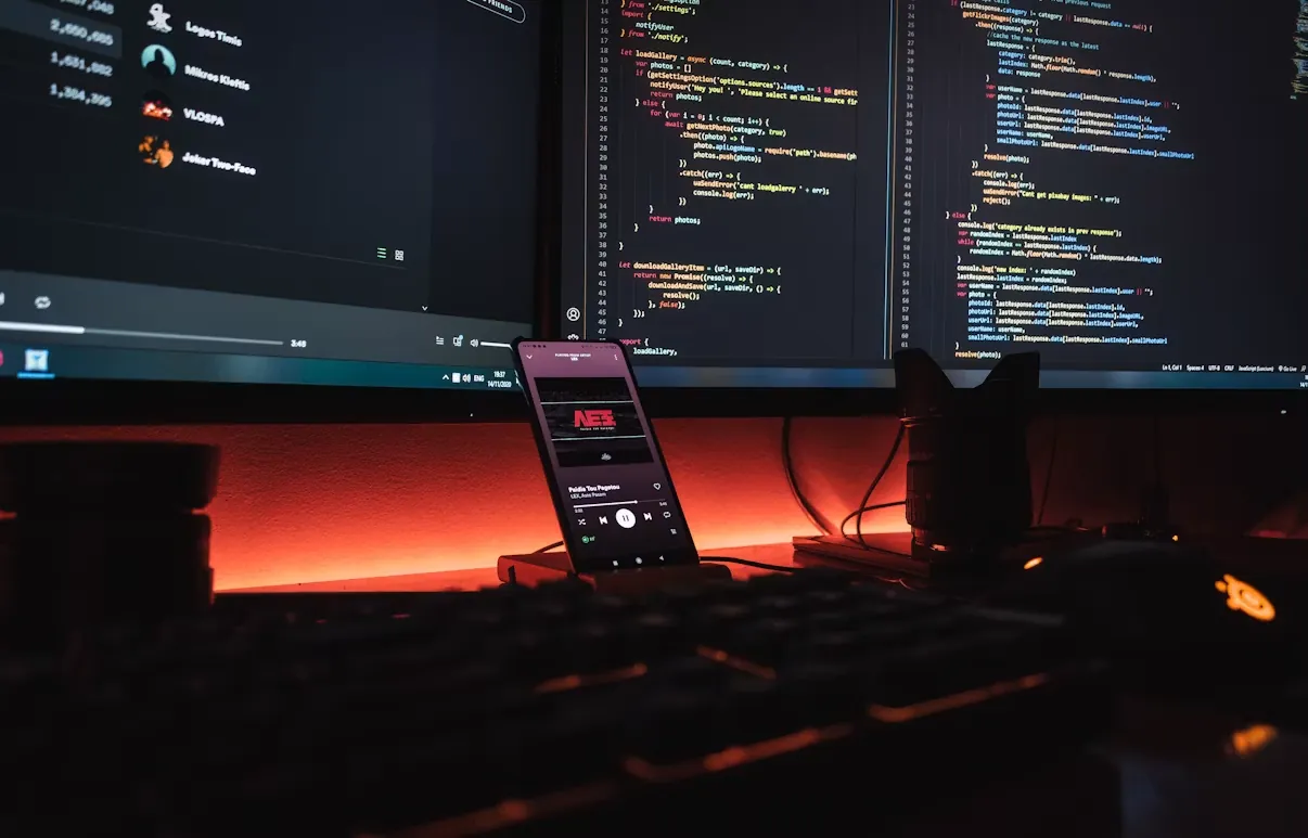 A developer’s dual-monitor setup lit in warm light.